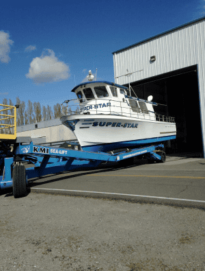 Fishing boat on trailer exiting warehouse